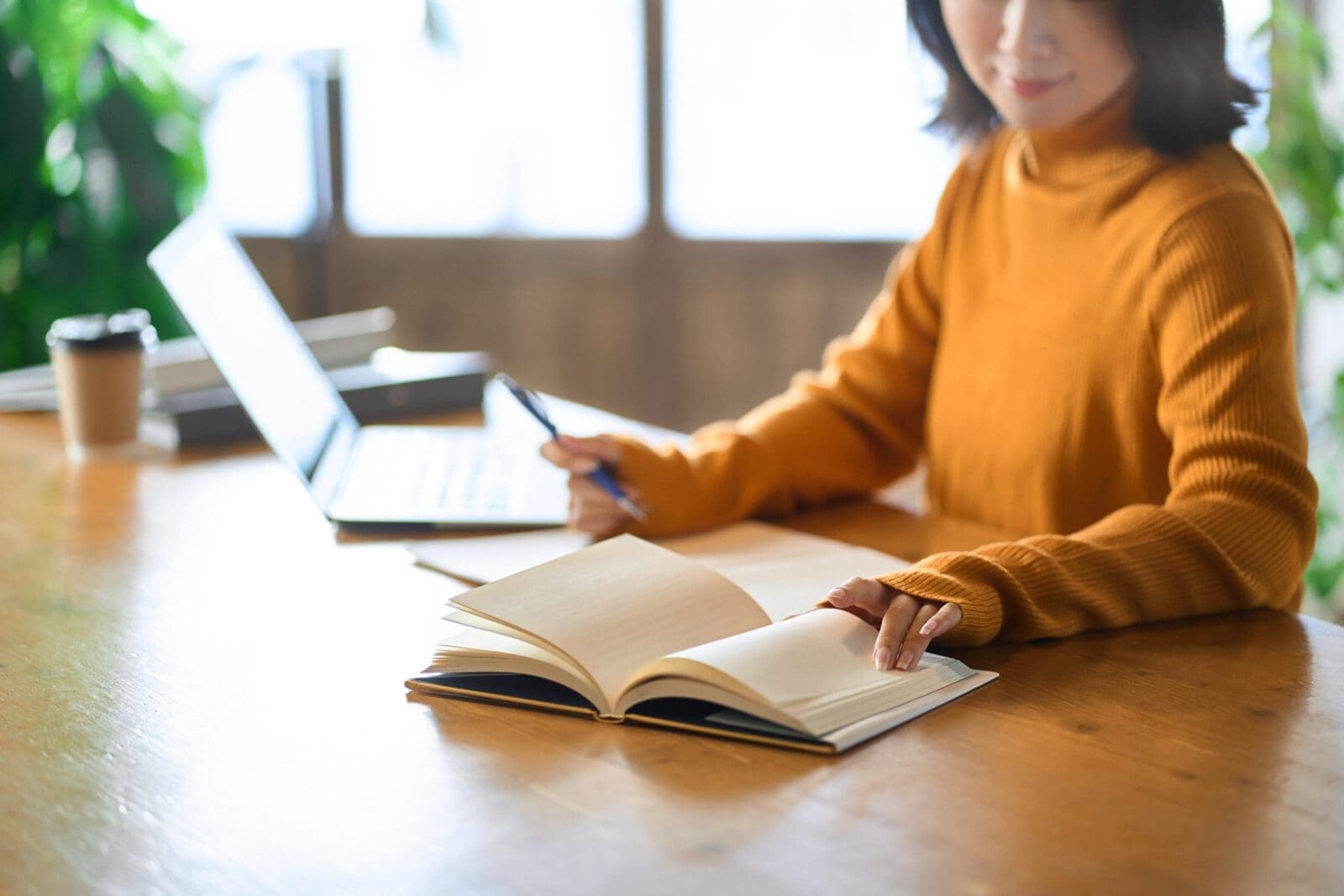 Asian woman's hand studying for qualifications.