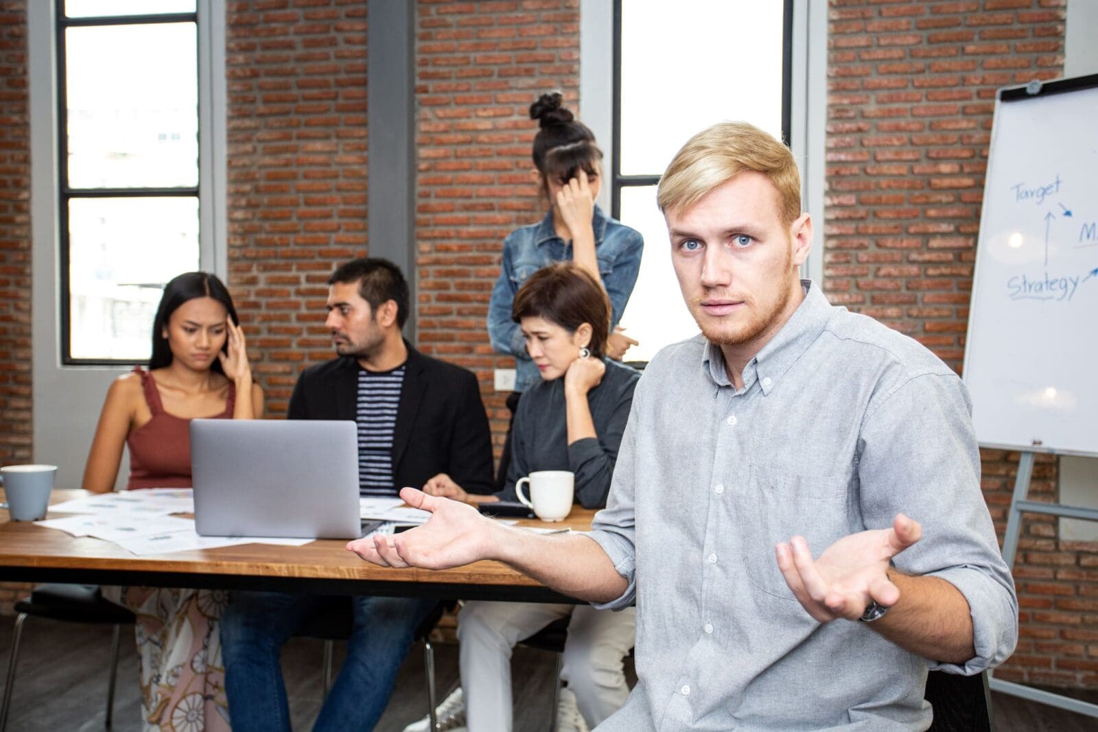 Man sitting with a team, confused about the worst KPI question you can answer. Credit: https://www.istockphoto.com/portfolio/Bavorndej?mediatype=photography