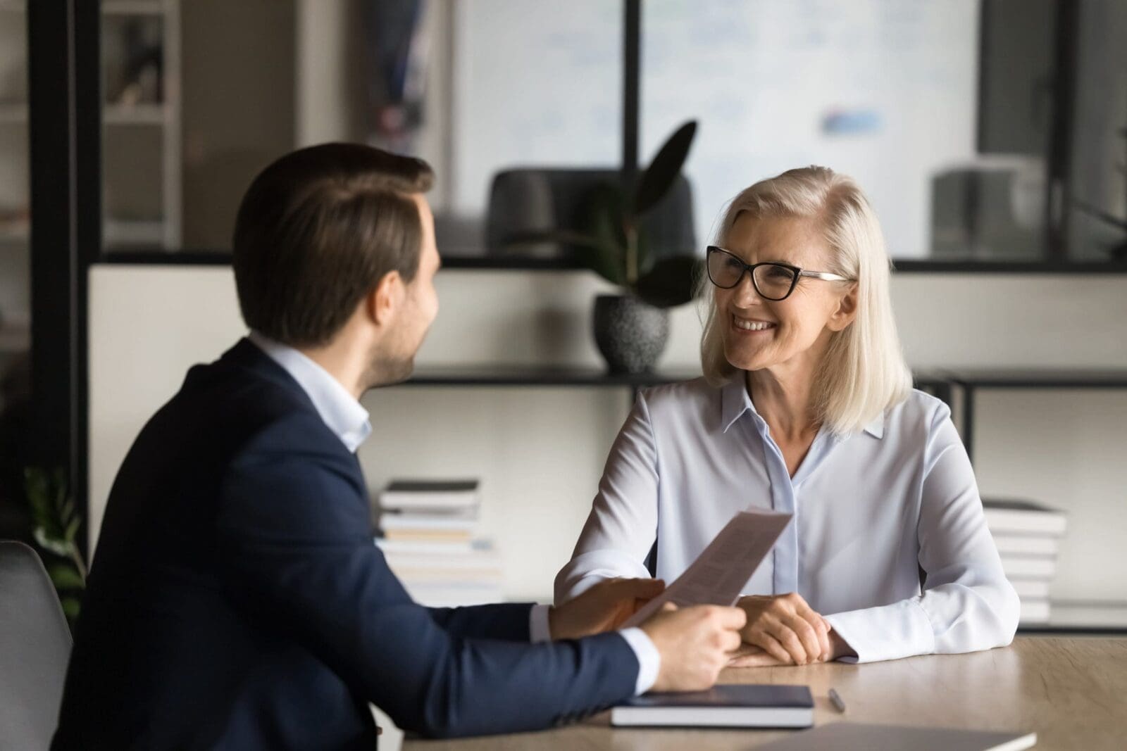 Middle-aged business woman and young business man discussion. CREDIT: https://www.istockphoto.com/portfolio/fizkes