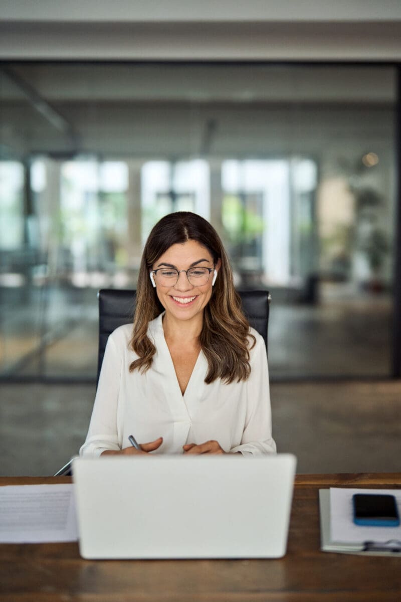 A female executive watching a webcast on her laptop. CREDIT: https://www.istockphoto.com/portfolio/insta_photos