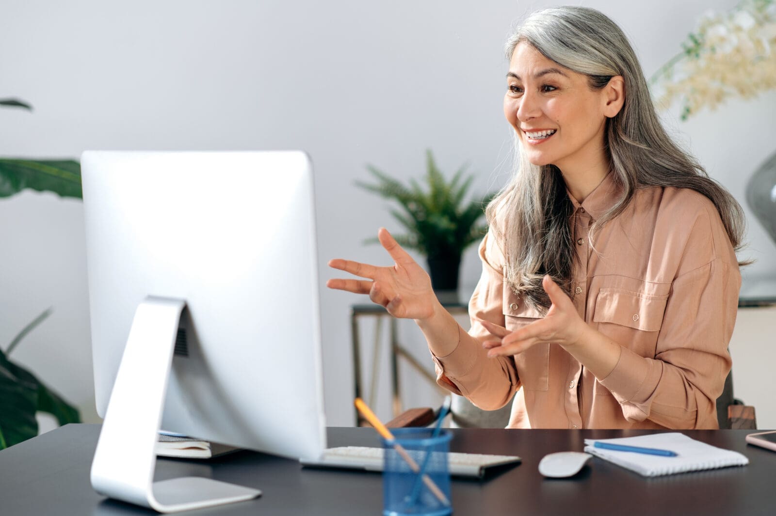 Mature Asian woman looking pleased with the Smart Chart on her computer screen. CREDIT: https://www.istockphoto.com/portfolio/KaterynaOnyshchuk