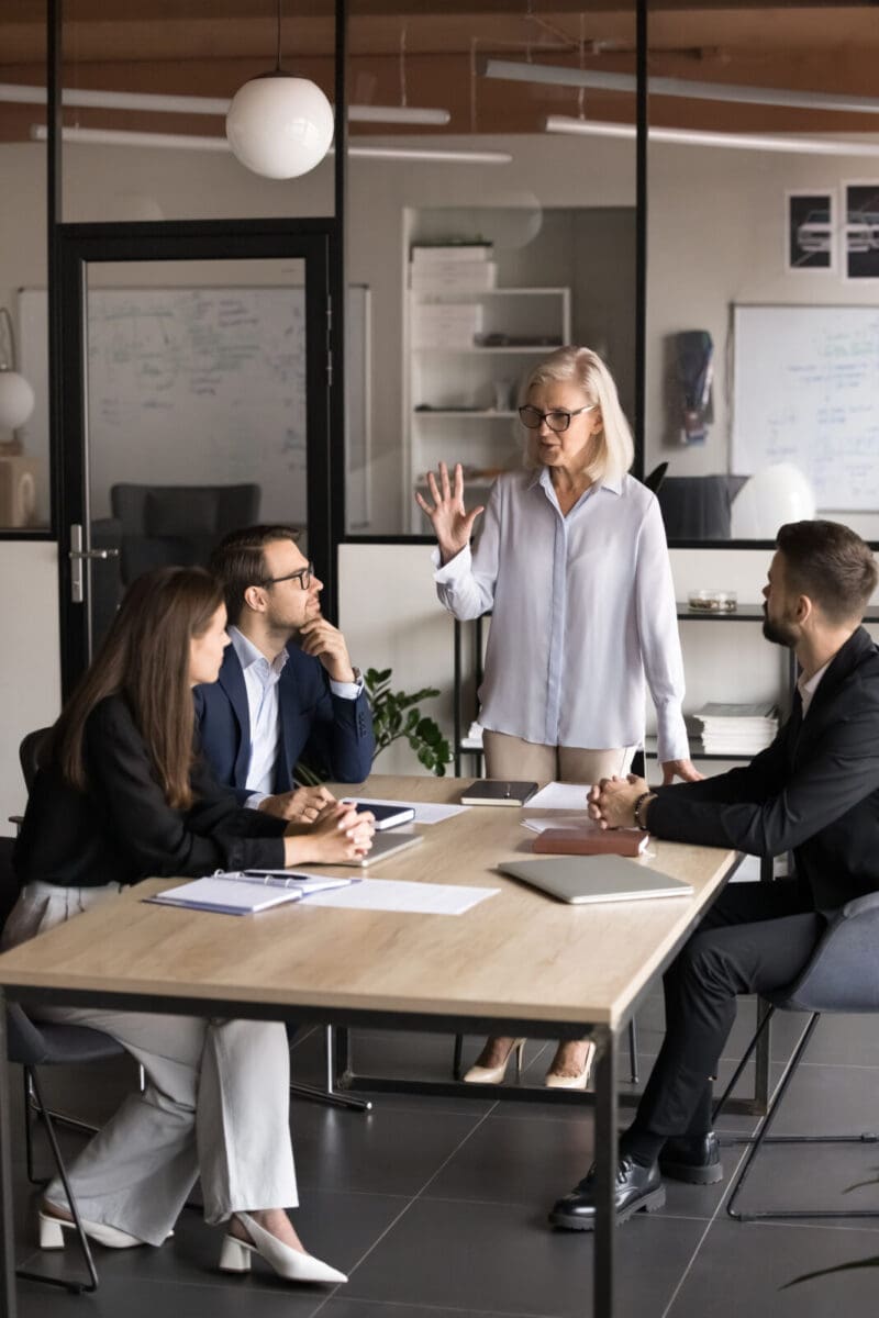 Middle-aged business woman leading a team through a strategic discussion. CREDIT: https://www.istockphoto.com/portfolio/fizkes
