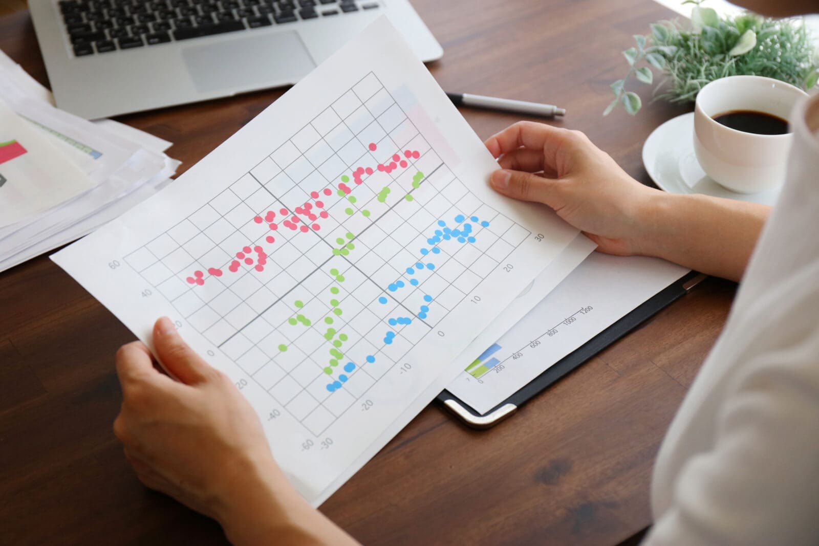 A businesswoman holding a graph of correlations between indicators. CREDIT: https://www.istockphoto.com/portfolio/kukai