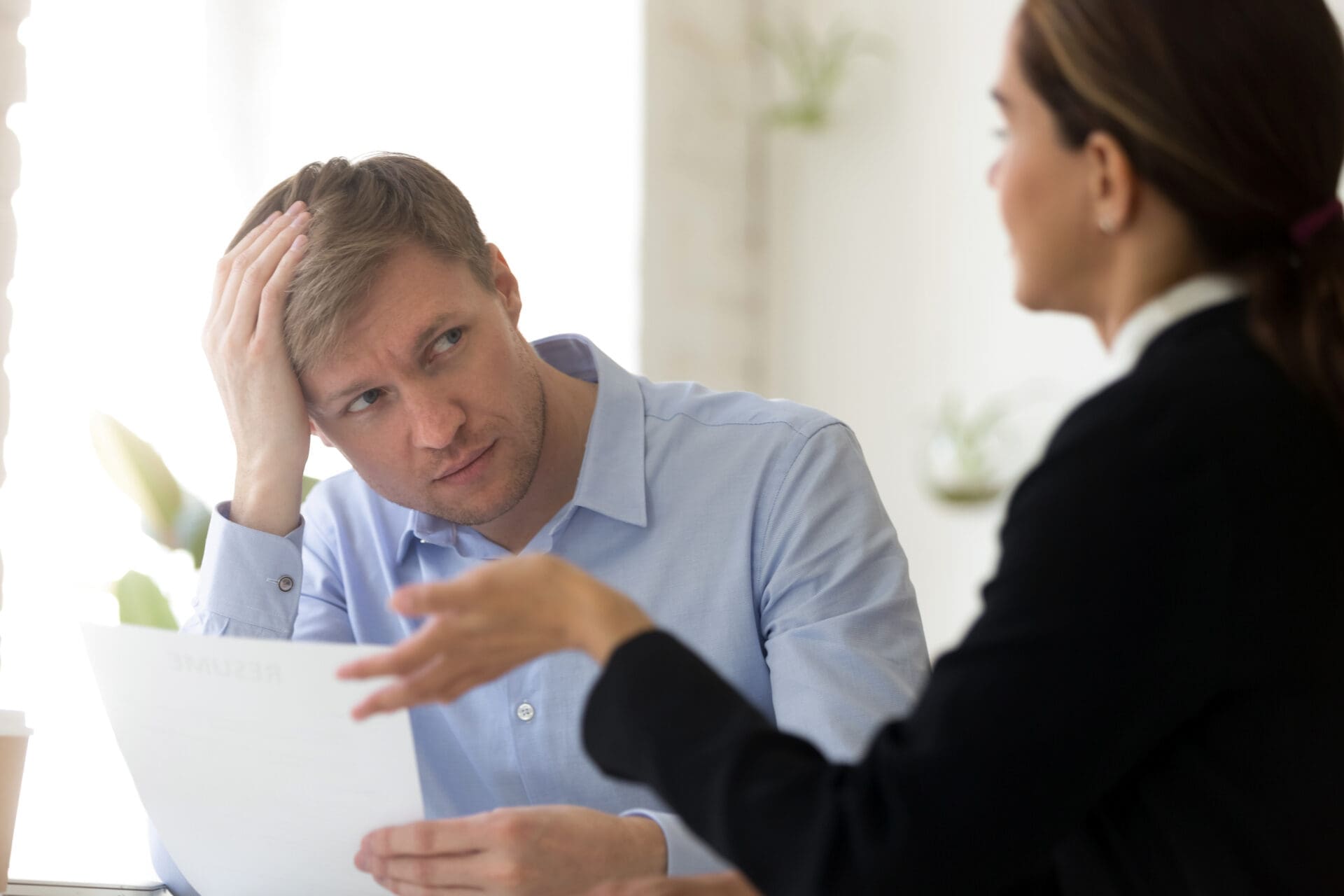 Male employee looking uncomfortable in meeting with manager. CREDIT: https://www.istockphoto.com/portfolio/fizkes
